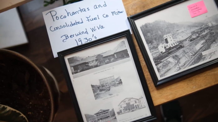 Picture frames on a table of a Black coal camp. The card above it reads, "Pocahantas and Consolidated Fuel Co. Mine, Berwind, W.Va. 1930s."
